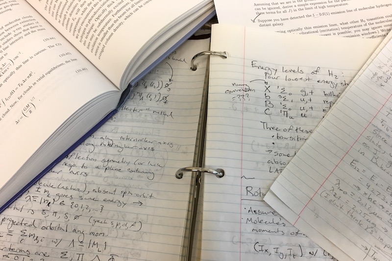 A photo of pages of notes, homework, and a book